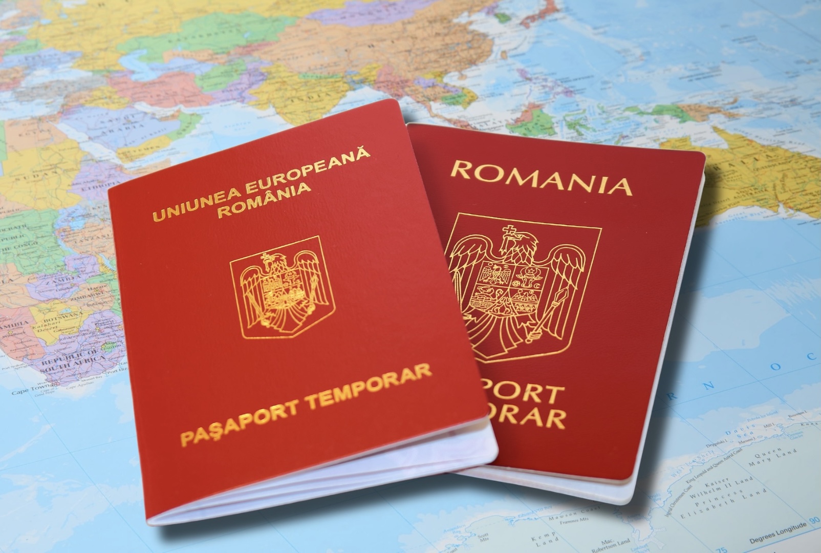 Passaporte romeno europeu com o brasão da Romênia sobre fundo azul para processo de dupla cidadania.